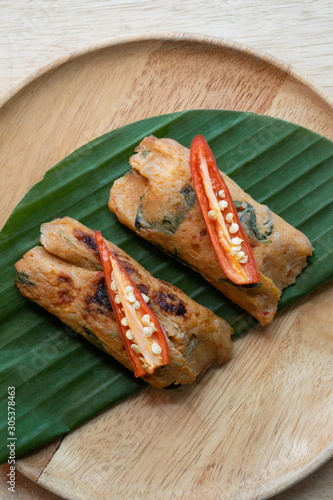 Grilled fish with curry paste and coconut milk on banana leaf in wooden dish,Thai food.