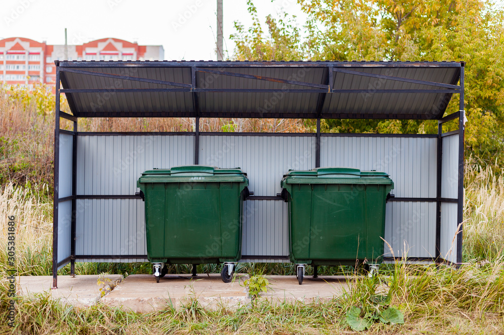 Two green dumpsters on the street under a canopy. Garbage reform in Russia. Container Two green dumpsters on the street under a canopy. Garbage reform in Russia. Container