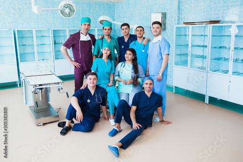 Fototapeta Naklejka Na Ścianę i Meble -  Portrait team professional doctors. The staff of the medical faculty. multinational people - doctor, nurse and surgeon. A group of graduates of a medical university in a surgical room.