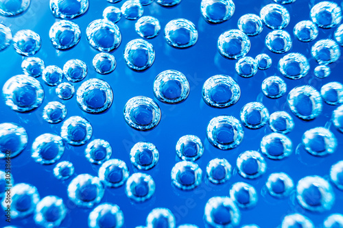 Bubbles of mineral water close-up. Macro photo in blue shades. Background stylish image, minimalism.