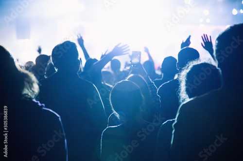 Silhouette of a crowd of fans at a concert.