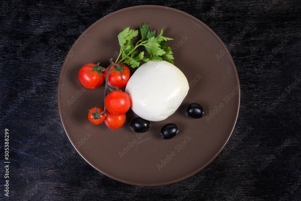 Top view of mozzarella cheese, olives, tomatoes, parsley on dish Top view of mozzarella cheese, olives, tomatoes, parsley on dish