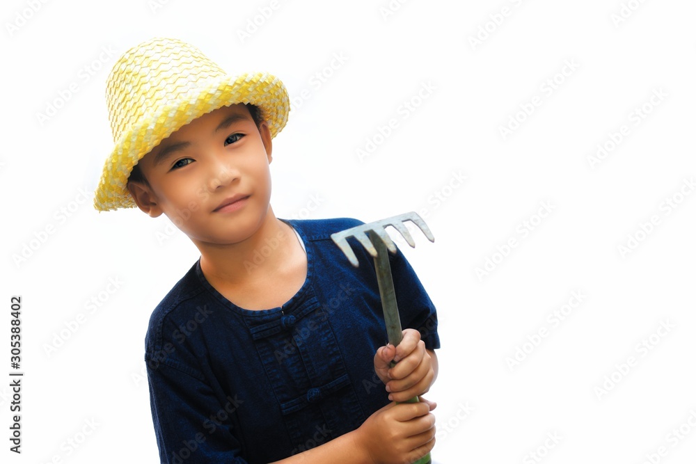Country boy wear blue shirt and hat holding a rake, Little boy in thailand's farmer dress, Farmer concept. Country boy wear blue shirt and hat holding a rake, Little boy in thailand's farmer dress, Farmer concept.