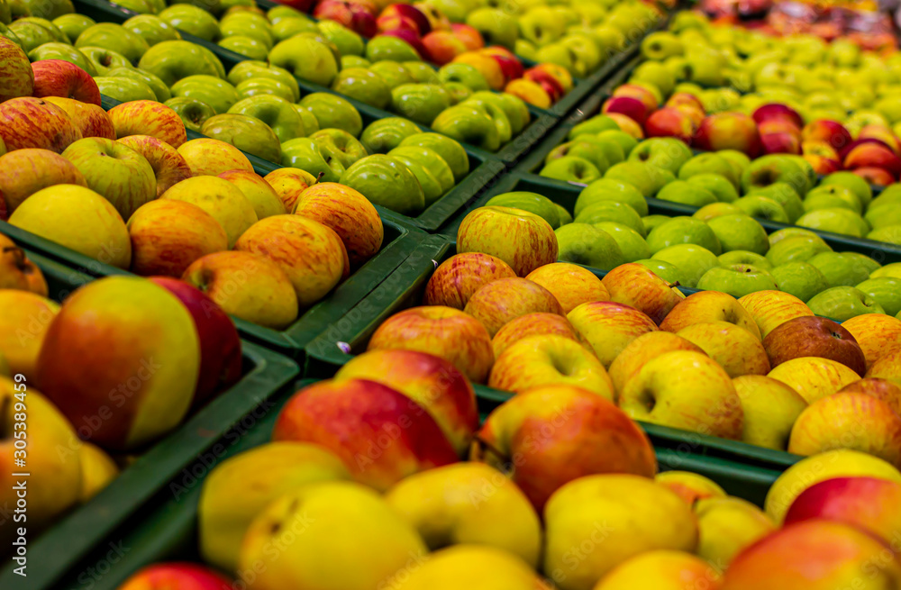  Apples in the store. Rows of apples in a supermarket. Boxes filled with apples of different varieties and colors in the store. The concept of harvest, healthy nutrition, healthy lifestyle, organic. 