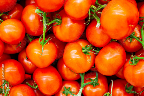 Lots of red fresh ripe tomatoes close up in the supermarket. Vegetables harvest. Food natural background . Vegetable background  concept of harvest  agriculture  veggie.