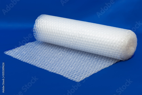 Packaging bubble wrap roll on blue photo