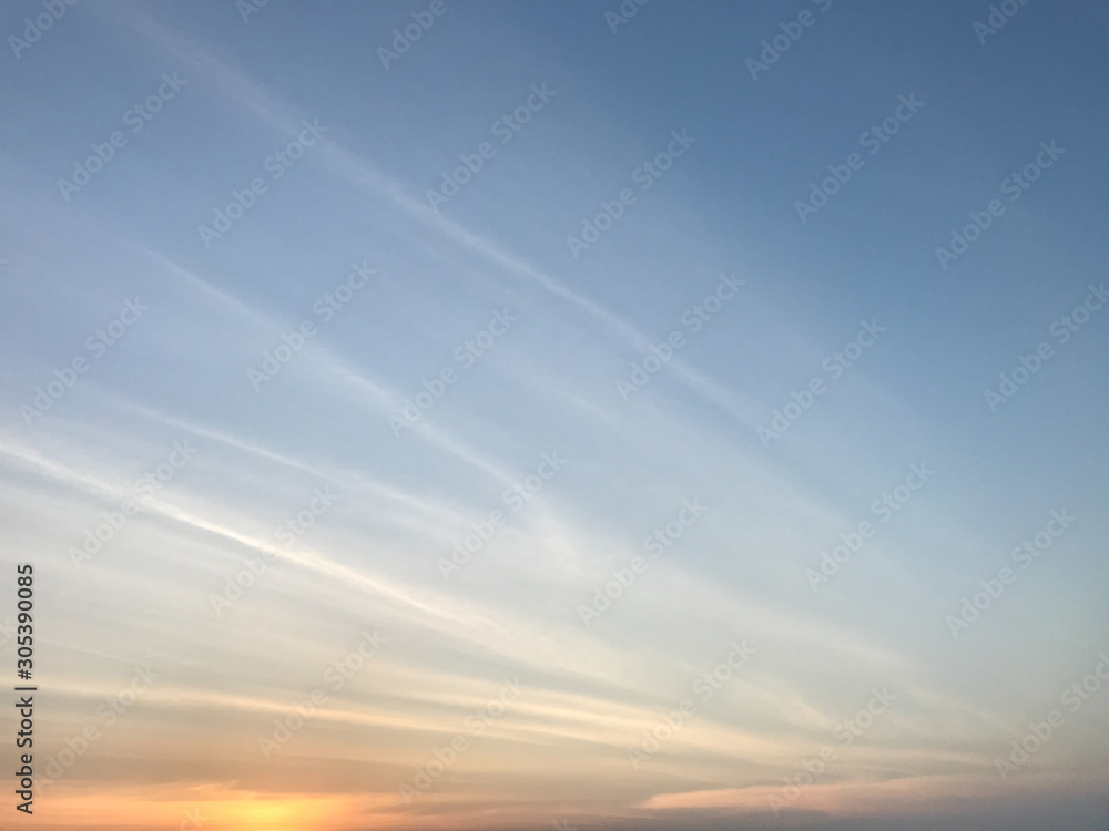 amazing gold sunset light with blue twilight sky and white lines of clouds
