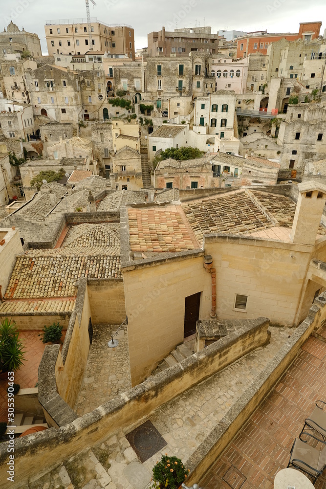 Streets, alleys and courtyards of the city of Matera. Typical houses built with blocks of tufa stone of beige color.