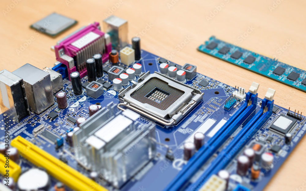 LGA socket on motherboard close-up. Blue motherboard. Processor and ram module beside. LGA socket on motherboard close-up. Blue motherboard. Processor and ram module beside.