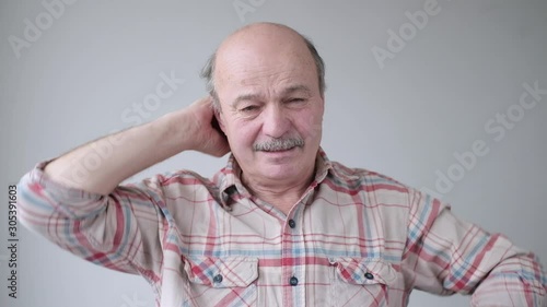 Senior hispanic man in pain with neck and head pain.