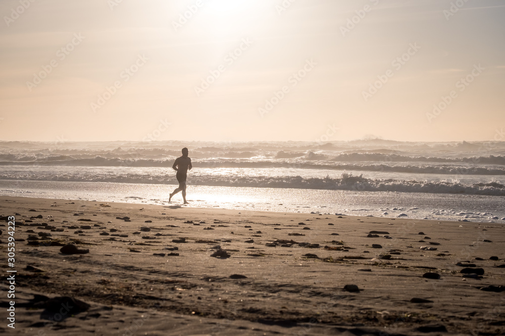 Men run of Sandy coast of the Atlantic Ocean and surf waves in Morocco
