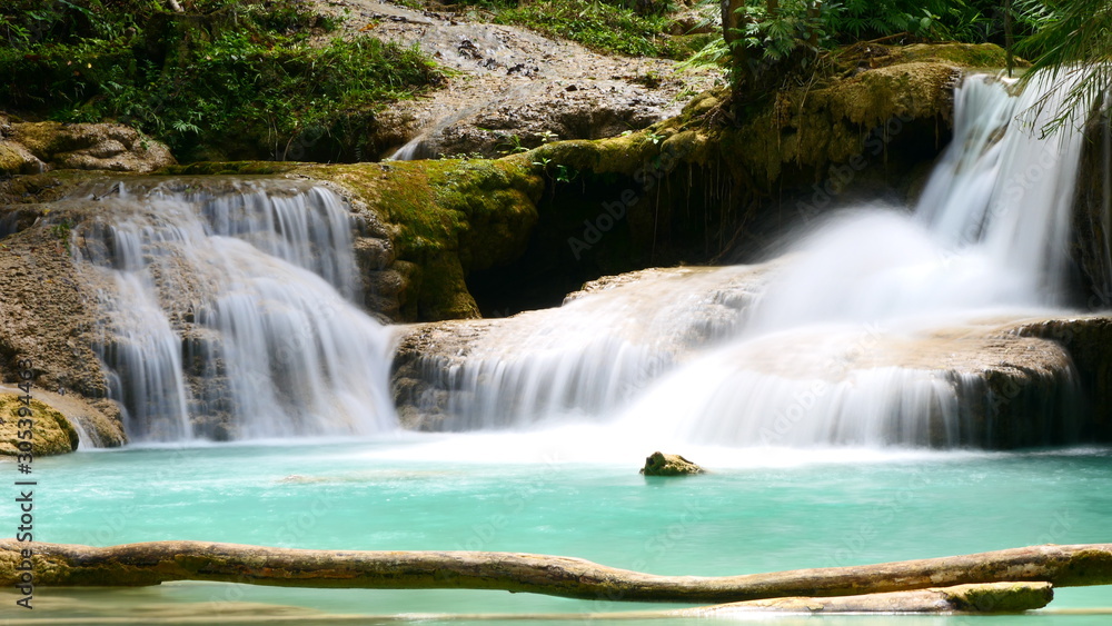 Obraz premium A beautiful rock formation with a small lake within the Kuang Si Falls in Luang Prabang, Laos