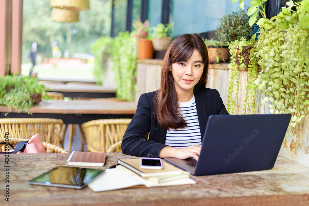 Young attractive business woman in her casual suit working on her computer at outdoor patio of her office, working mobile or young entrepreneur concept Young attractive business woman in her casual suit working on her computer at outdoor patio of her office, working mobile or young entrepreneur concept