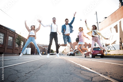Group of young people having fun together outdoors in urban background.