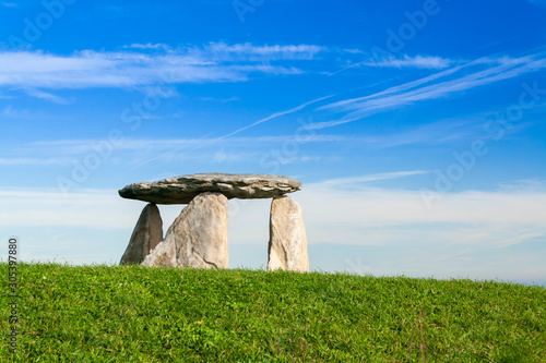 A menhir / standing stone in a park. Blue sky with clouds. Saint Peter's Mountain, La Coruna, Spain