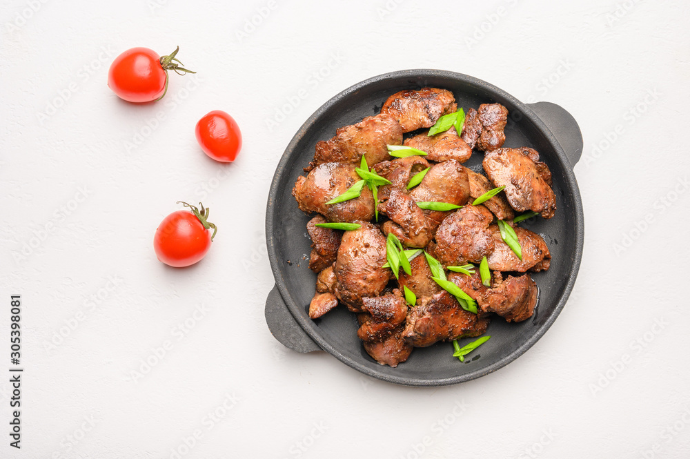 Homemade chicken liver fried with soy sauce, tomatoes, onions and spices on light background. Top view