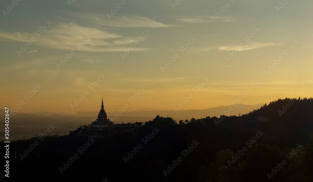 Mountain view panorama evening of Crystal Pagoda or Chedi Kaew on top hill with yellow sun light in the sky background, sunset at Wat Tha Ton, Tha Ton District, Fang, Chiang Mai, northern of Thailand.