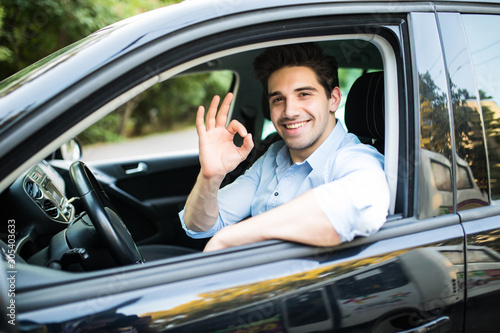 Young man in his car showing okay sign