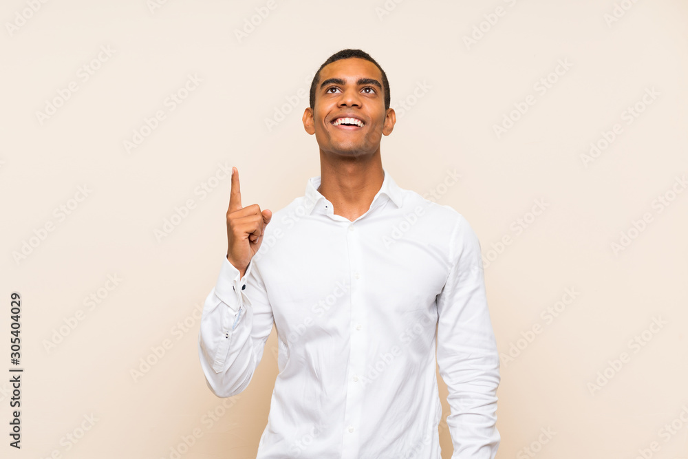 Young handsome brunette man over isolated background pointing up and surprised Young handsome brunette man over isolated background pointing up and surprised