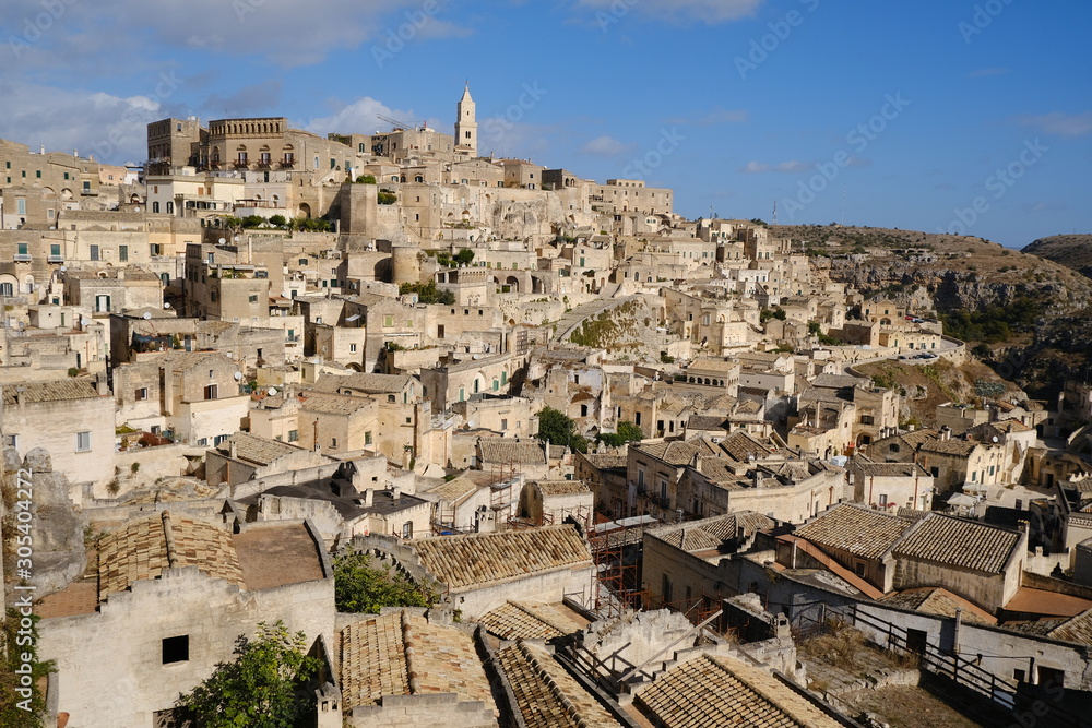 Panorama of houses and of the Sassi of Matera with roofs and streets. Blue sky with