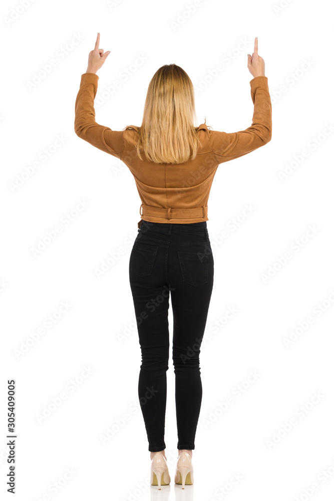Rear View Of Standing Woman With Arms Raised And Pointing Up. Rear View Of Standing Woman With Arms Raised And Pointing Up.