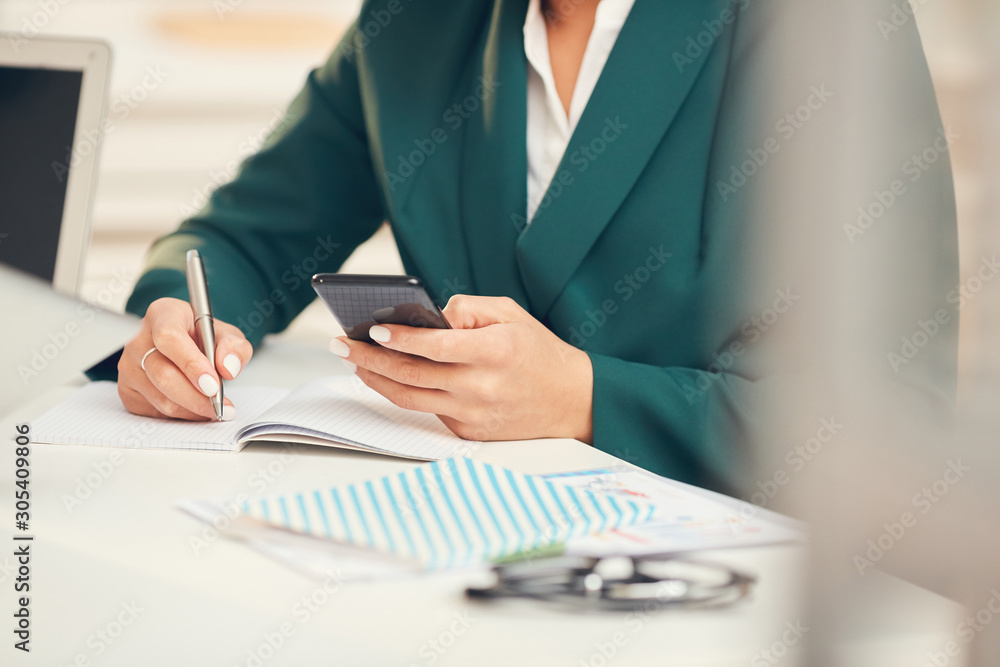 Fototapeta premium Close up of unrecognizable businessman using smartphone during business meeting in office, copy space
