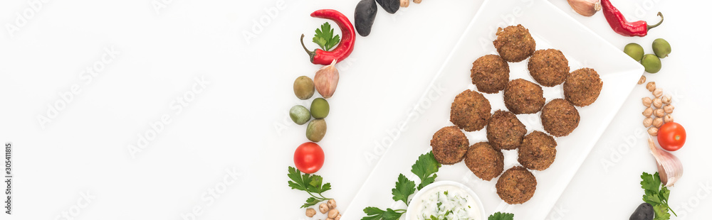 top view of vegetables arranged in round frame around falafel on plate with sauce on white background, panoramic shot top view of vegetables arranged in round frame around falafel on plate with sauce on white background, panoramic shot