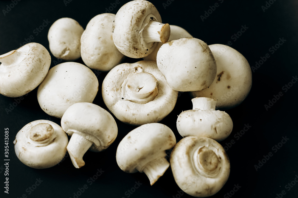champignon mushrooms on a black background. space for text champignon mushrooms on a black background. space for text