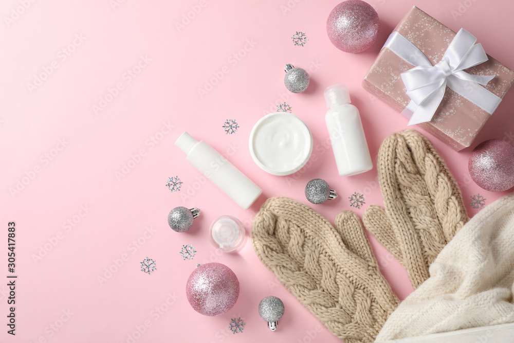 Set cosmetics, winter cream for skin, warm sweater and gloves on pink background, space for text. Top view Set cosmetics, winter cream for skin, warm sweater and gloves on pink background, space for text. Top view