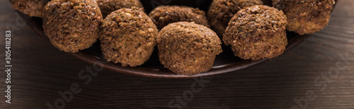 close up view of falafel balls on plate on wooden table, panoramic shot