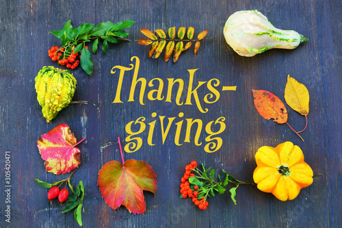 Thanksgiving background with pumpkins and leaves on old shabby board