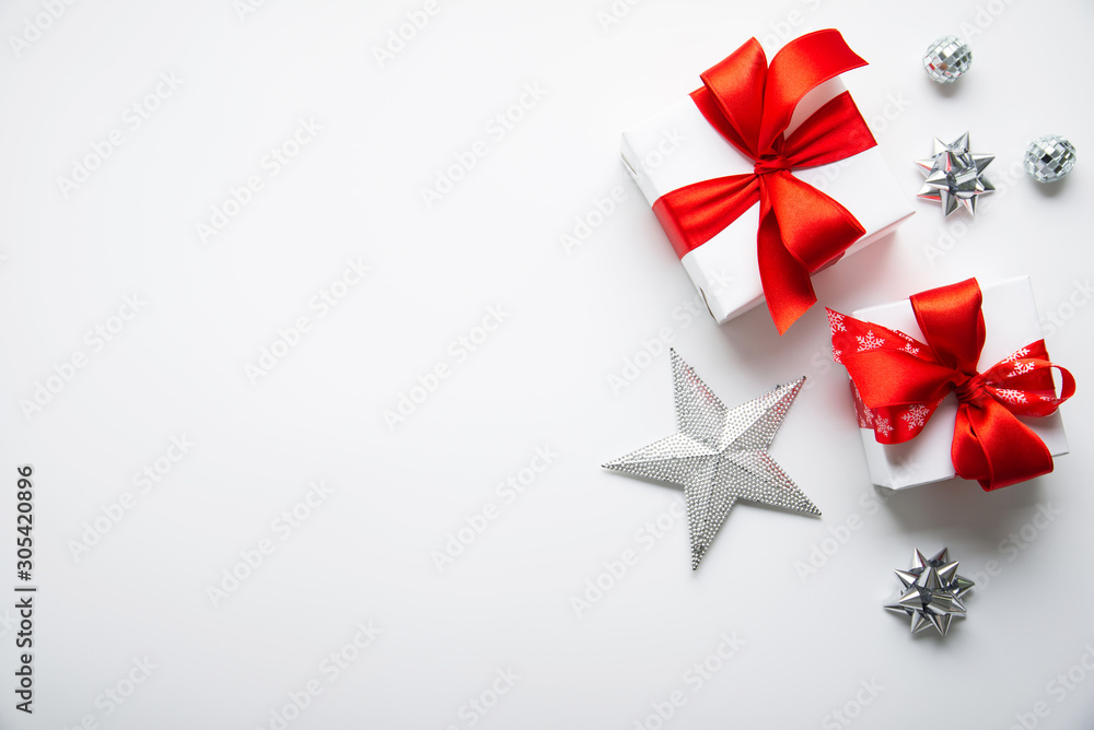 Christmas and New Year holiday background. Xmas greeting card. Christmas red ribbon gifts and ornaments on white background top view. Flat lay Christmas and New Year holiday background. Xmas greeting card. Christmas red ribbon gifts and ornaments on white background top view. Flat lay