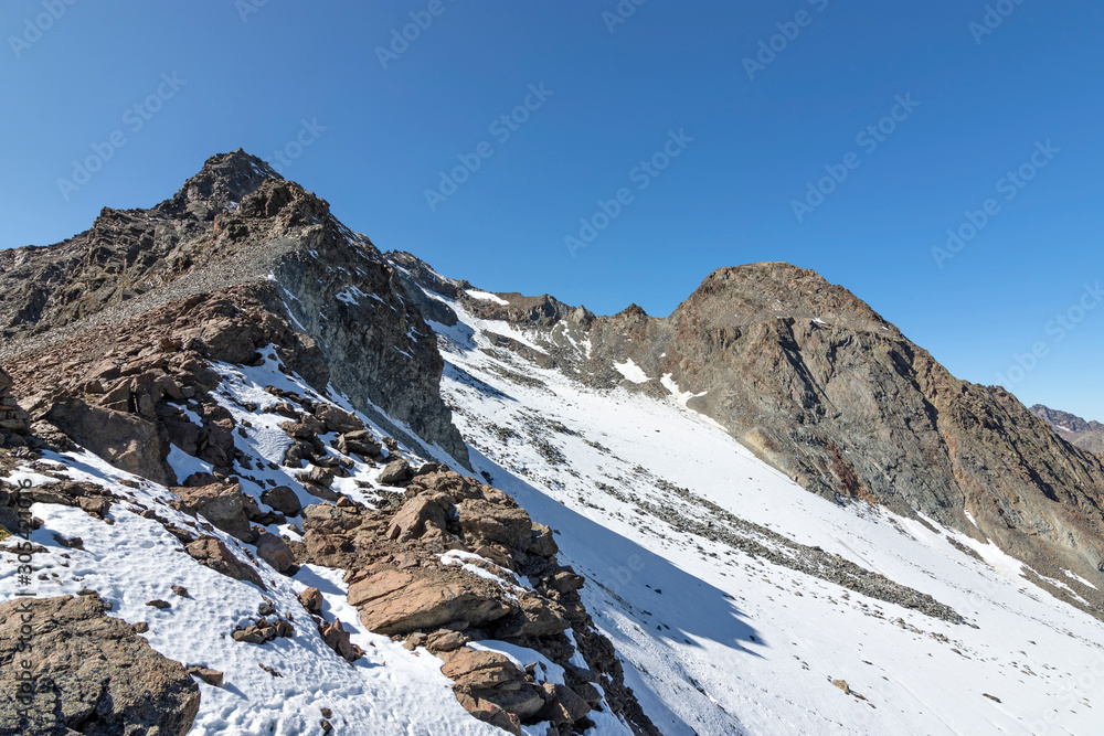 View to the summits of two rocky mountains with some snow and glacier in the Stubai Alps at a clear sunny day. Tirol, Austria View to the summits of two rocky mountains with some snow and glacier in the Stubai Alps at a clear sunny day. Tirol, Austria