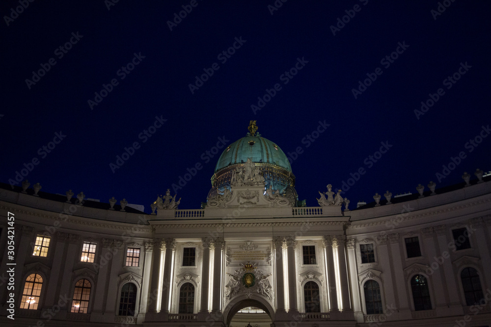 Obraz premium Michaelerkuppel, the dome of the entrance to the Hofburg palace at night, on Michaeler platz. Hofburg is the former Austro Hungarian imperial palace of Vienna, Austria