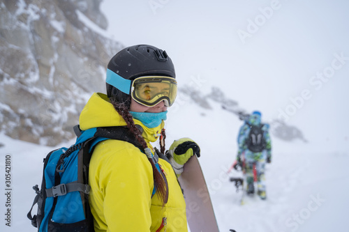 Photo of sports woman in helmet and glasses with snowboard at ski resort in afternoon