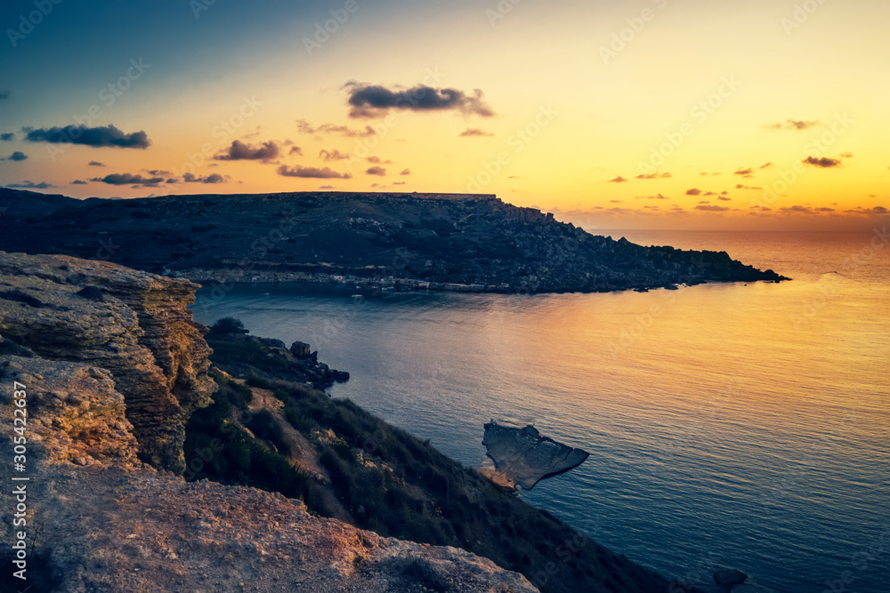 beautiful sunset and seascape view of Golden Bay, Malta, travel background