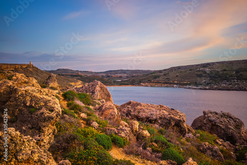 beautiful sunset and seascape view with mountains of Golden Bay, Malta, travel background