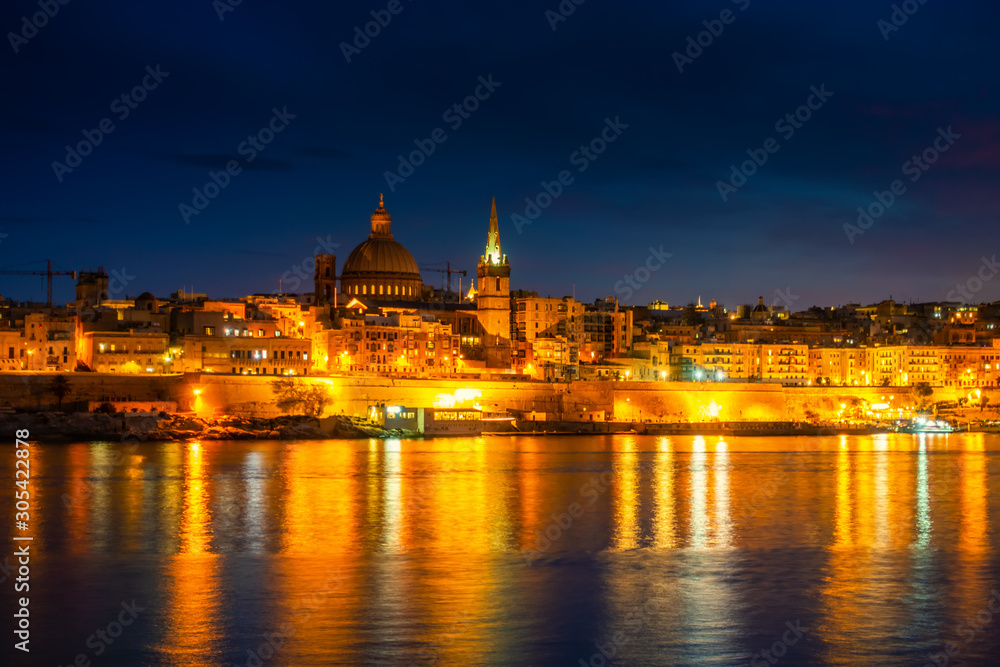 beautiful view in front of night scene of Basilica Our Lady Mount Carmel in Valletta from Sliema, Malta