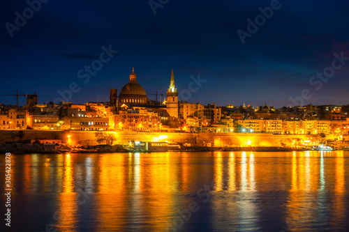 beautiful view in front of night scene of Basilica Our Lady Mount Carmel in Valletta from Sliema, Malta