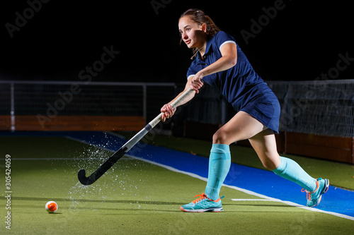 Fotografie Young woman performing short or penalty corner