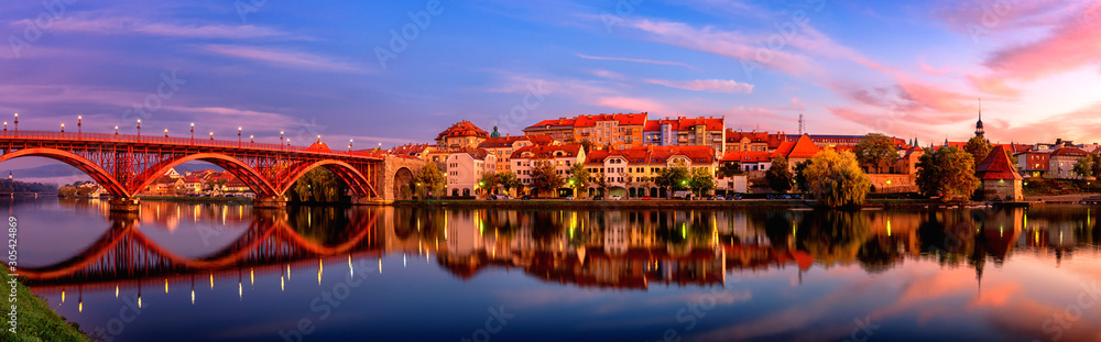 Amazing view of Maribor Old city, Main bridge (Stari most) on the Drava river before sunrise, Slovenia. Scenic cityscape with sky and reflection, travel background for wallpaper or guide book