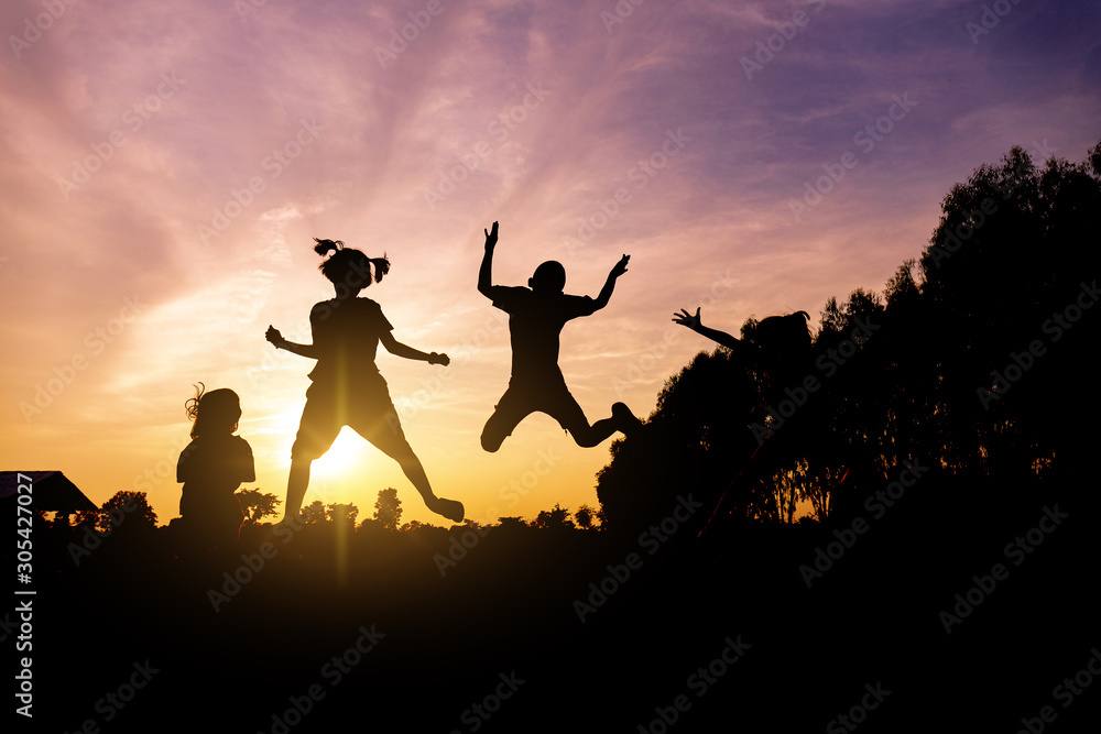 silhouette of lifestyle children active playing up hands and jumping joy on summer