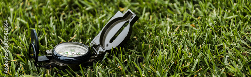 panoramic shot of black retro compass on green grass photo