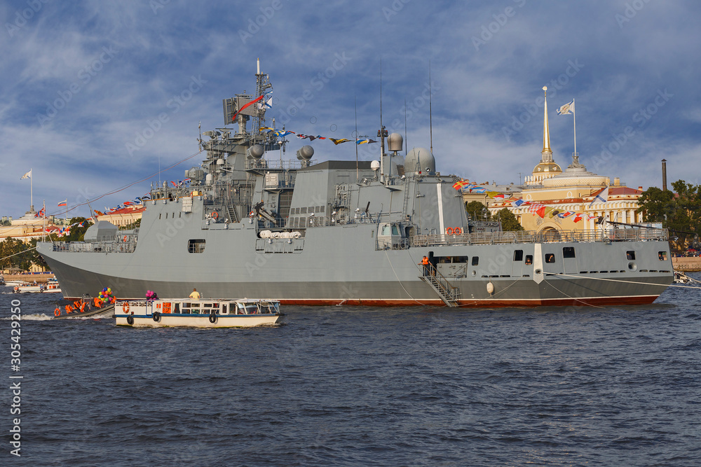 military ship on Neva river in St. Petersburg against the blue sky and the city.