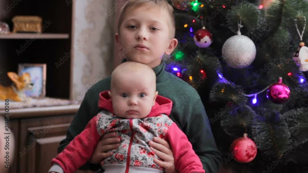 shooting children near the Christmas tree,boy with little sister shooting next to Christmas tree shooting children near the Christmas tree,boy with little sister shooting next to Christmas tree