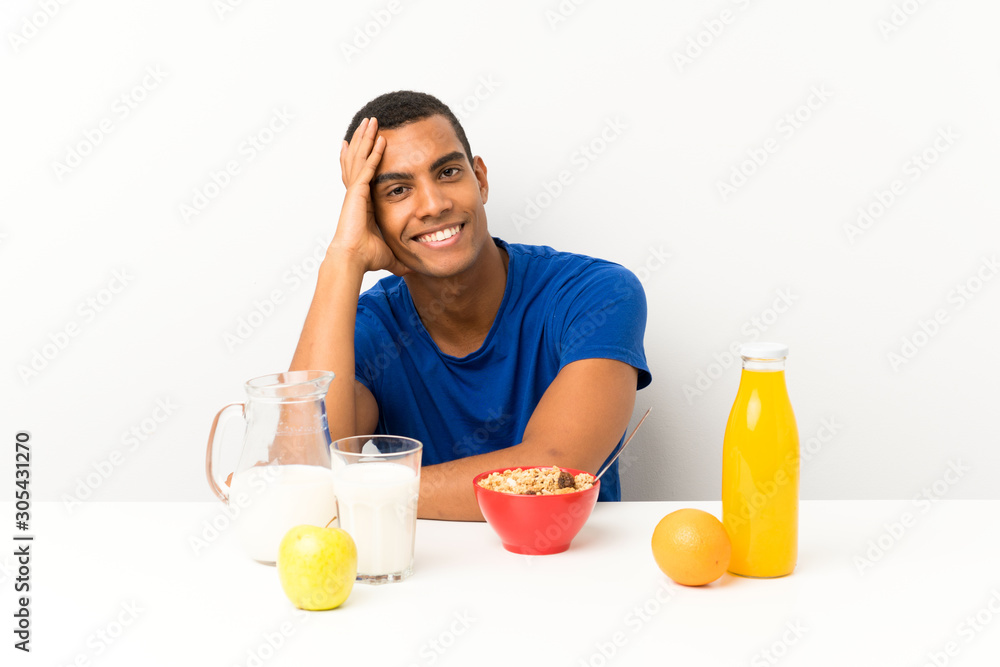 Young man having breakfast in a table laughing