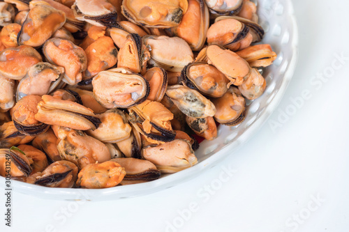 Boiled mussels in a plate on a white background