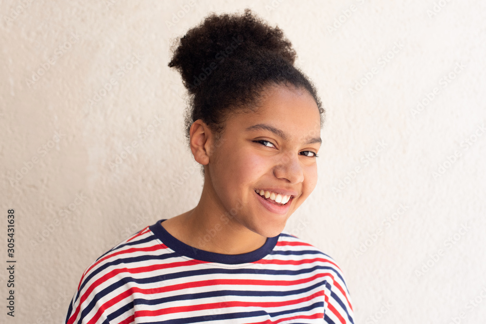Close up of african american girl smiling and glancing by white background Close up of african american girl smiling and glancing by white background