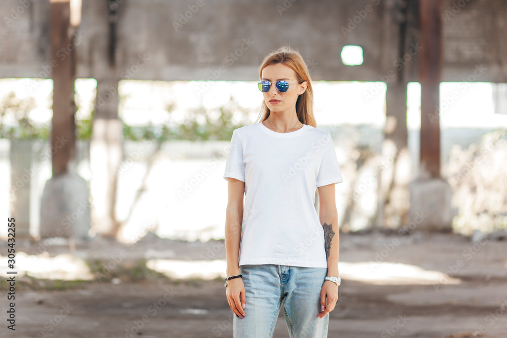 Girl wearing t-shirt, glasses  posing against street , urban clothing style. Street 
