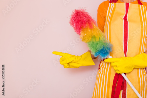 Image of housewife holding duster and pointing.